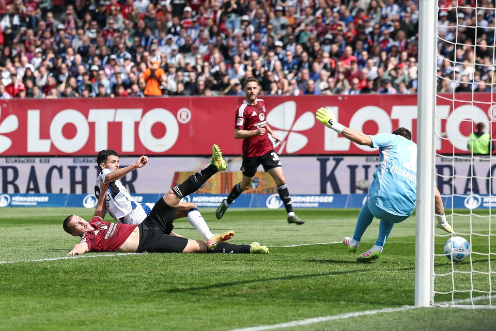 Die Großchance zum 1:1 für Nürnberg: Ondrej Karafiat (l) scheitert im Fallen an HSV-Torwart Daniel Heuer Fernandes. — © Daniel Löb/dpa