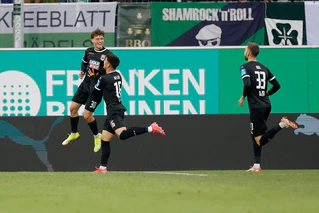 Die Ulmer Spieler feiern Matchwinner Maurice Krattenmacher (l) nach seinem Treffer.  — © Heiko Becker/dpa