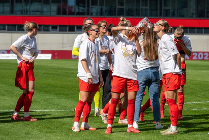 In Meister-Shirts und mit Bier feiern die Bayern-Fußballerinnen den Titel. — © Leonie Asendorpf/dpa